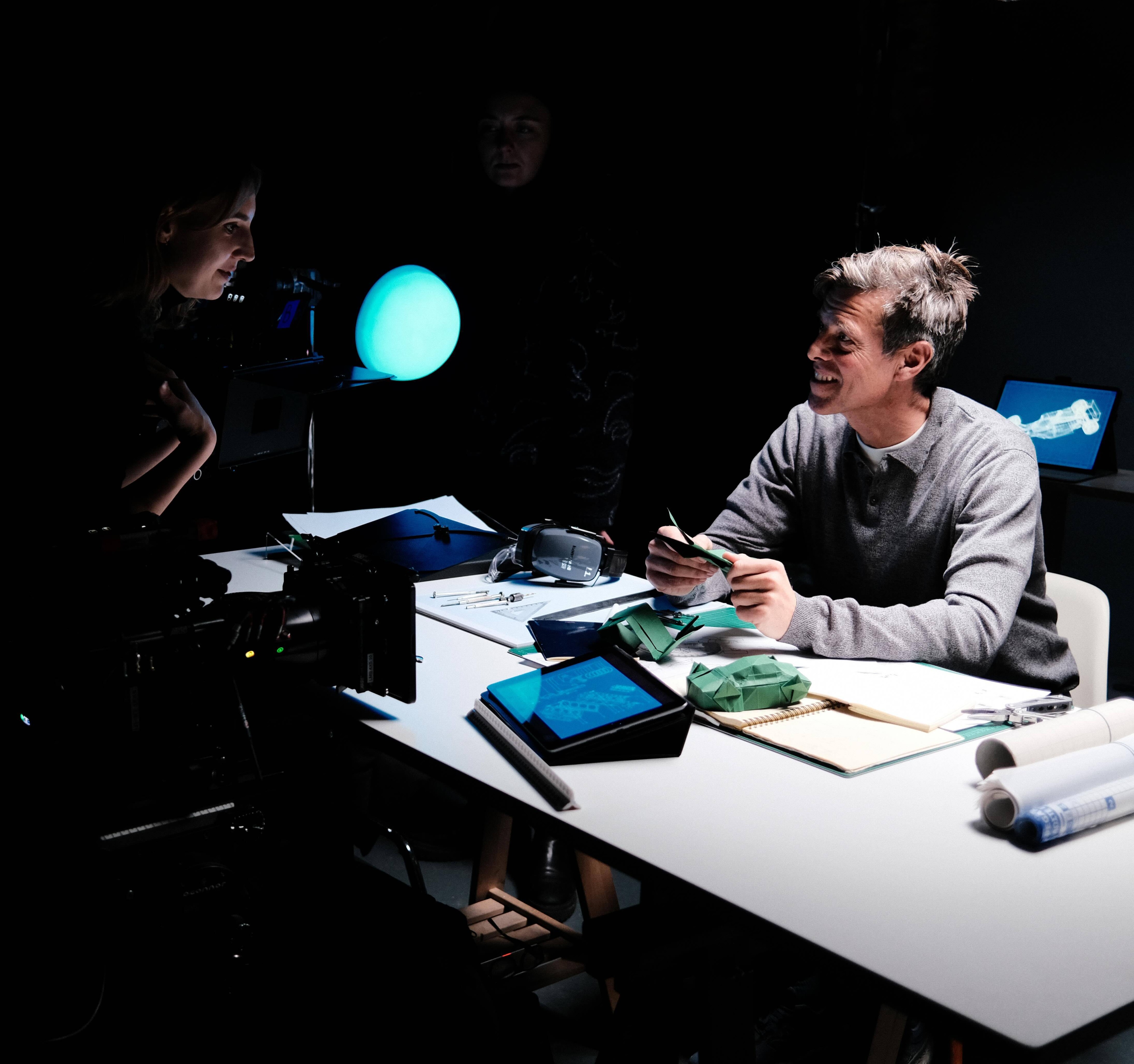 A director on a video shoot directs an actor